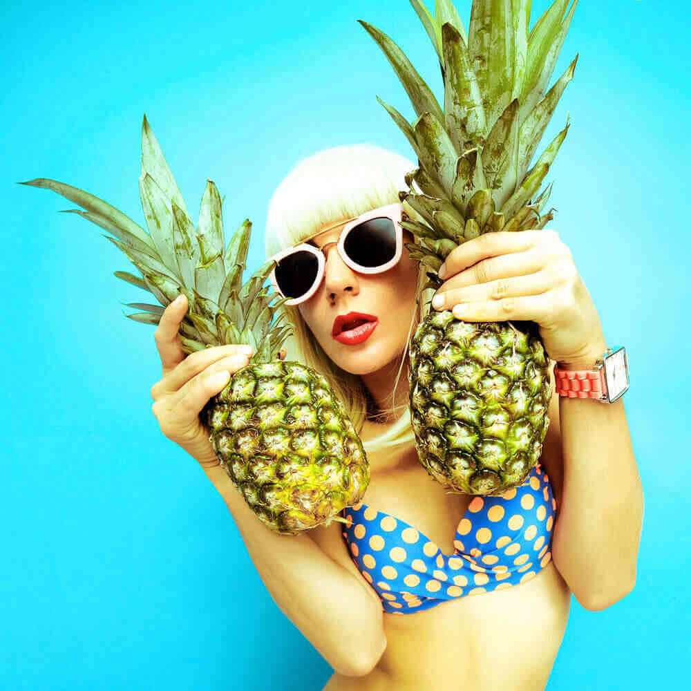 Sexy blonde picking pineapple